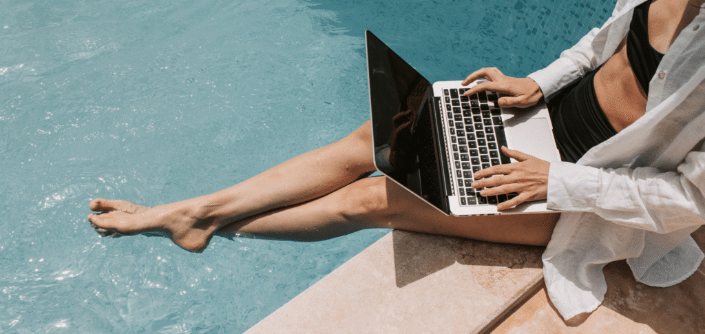 Woman Working By The Pool | 6 Tips to Keep Your Marketing Powerful During Holiday Season